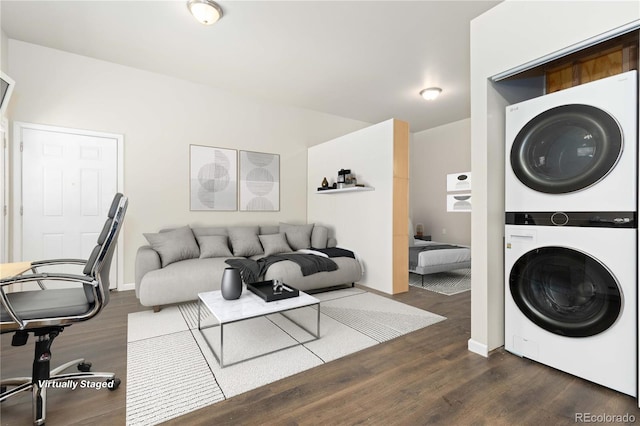 clothes washing area featuring dark wood-type flooring and stacked washer and clothes dryer