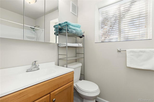 bathroom featuring vanity, toilet, and walk in shower