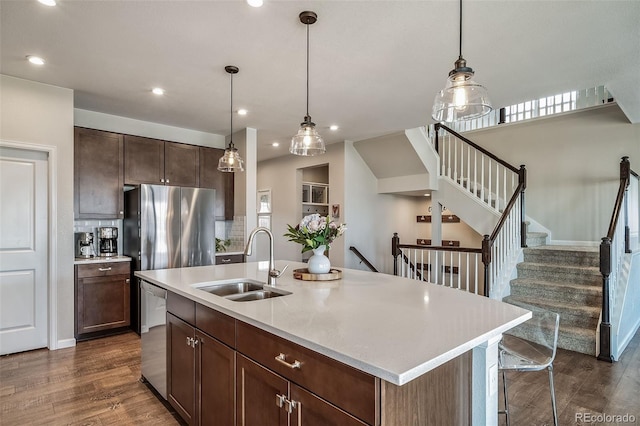 kitchen featuring light countertops, a sink, dark wood-style flooring, and stainless steel appliances