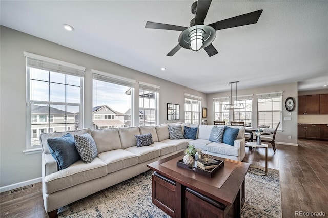 living room with baseboards, ceiling fan, dark wood-style floors, and visible vents