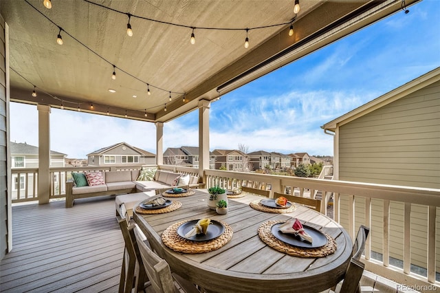 wooden terrace with outdoor dining area and a residential view