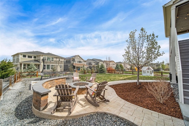view of patio / terrace featuring a residential view, a fire pit, and a fenced backyard