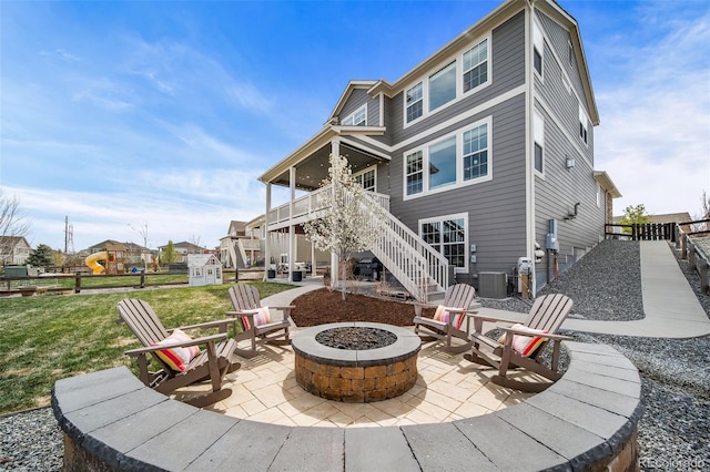 rear view of property featuring stairs, cooling unit, a fire pit, and a patio