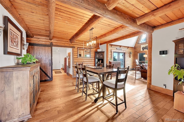 dining area with vaulted ceiling with beams, log walls, a barn door, wooden ceiling, and light hardwood / wood-style flooring