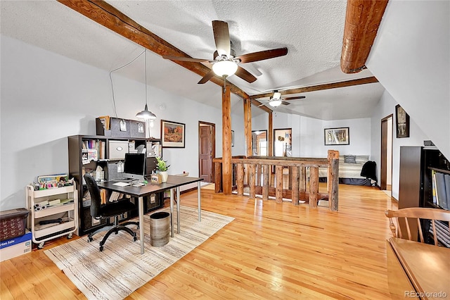 office space featuring lofted ceiling with beams, hardwood / wood-style floors, and a textured ceiling