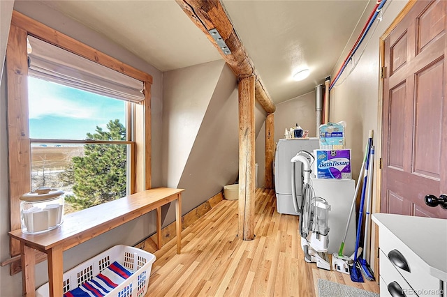 laundry area with separate washer and dryer and light hardwood / wood-style floors