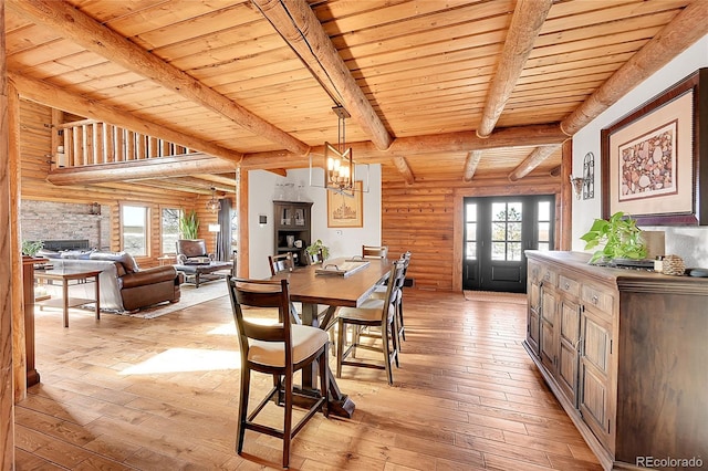 48155 E 56th Ave, Bennett, CO 80102 - dining room with wood ceiling with exposed beams, light wood-type flooring, a chandelier, rustic walls, and a fireplace