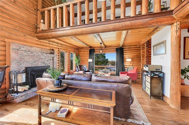 48155 E 56th Ave, Bennett, CO 80102 - living area with a wood stove, rustic walls, light wood-style floors, and wood ceiling with exposed beams