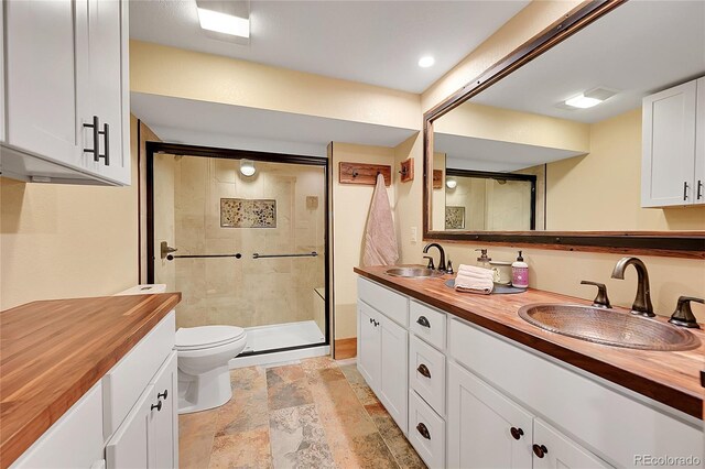 48155 E 56th Ave, Bennett, CO 80102 - bathroom with toilet, double vanity, a shower stall, and stone finish floors