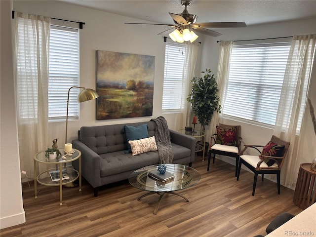 living area featuring a ceiling fan, a healthy amount of sunlight, and wood finished floors
