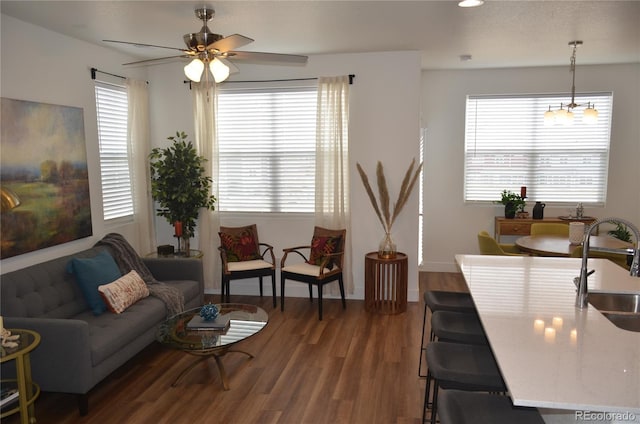 living area featuring baseboards, a healthy amount of sunlight, ceiling fan, and wood finished floors