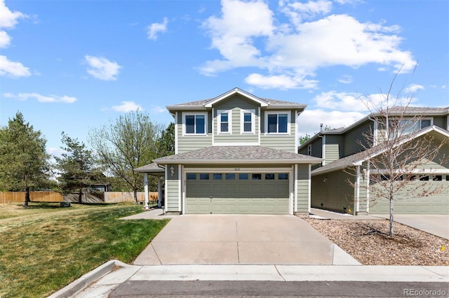 traditional home featuring a garage, fence, driveway, and a front yard