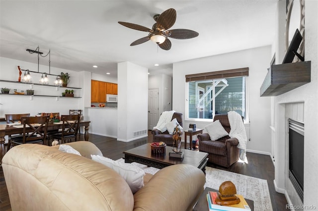 living area with visible vents, a fireplace, dark wood-type flooring, recessed lighting, and a ceiling fan
