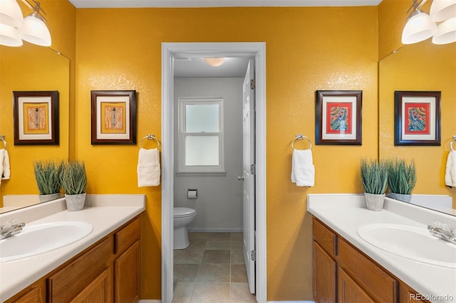 bathroom featuring a sink, two vanities, and toilet