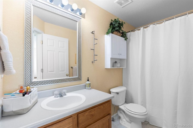bathroom featuring vanity, toilet, and visible vents