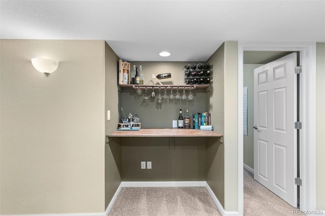 bar with baseboards, carpet flooring, and a bar
