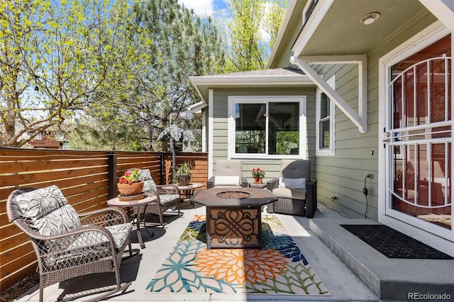 view of patio / terrace featuring an outdoor living space with a fire pit and fence