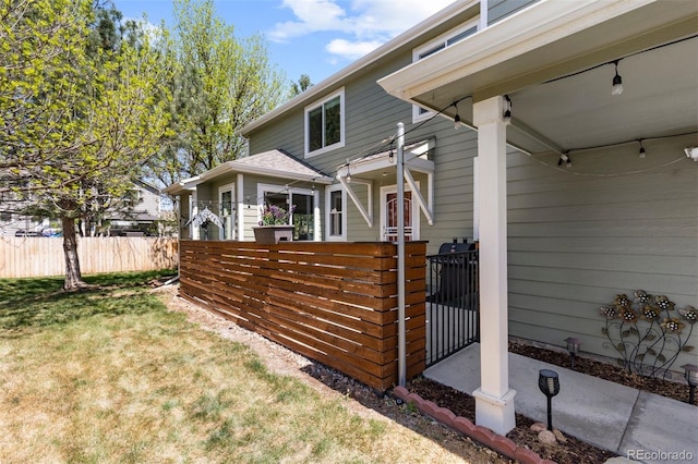 exterior space with a lawn, fence, and a gate