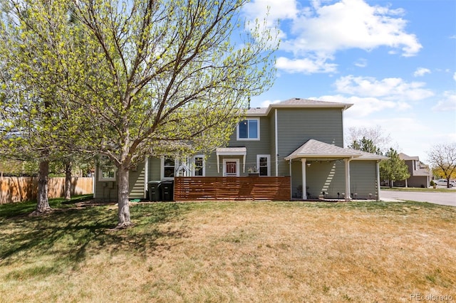 back of property featuring fence and a yard