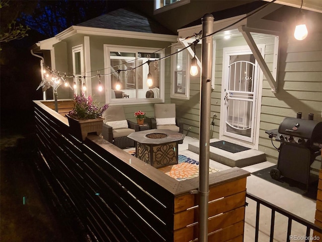 patio at night with a grill and an outdoor fire pit
