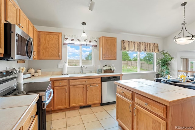 4873 Eckert St, Castle Rock, CO 80104 - kitchen with stainless steel appliances, a sink, tile countertops, light tile patterned floors, and decorative light fixtures