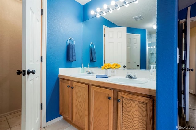 4873 Eckert St, Castle Rock, CO 80104 - bathroom with double vanity, tile patterned flooring, a shower with door, and baseboards