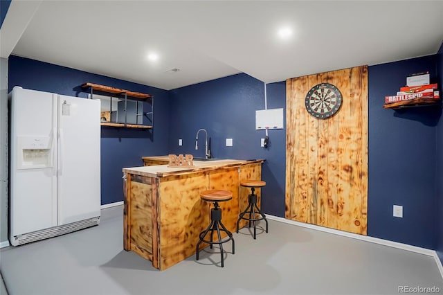 4873 Eckert St, Castle Rock, CO 80104 - indoor wet bar with white refrigerator with ice dispenser, concrete floors, and baseboards