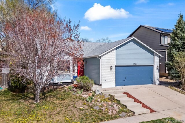 5965 Corinth Dr, Colorado Springs, CO 80923 - view of front of house with an attached garage, driveway, brick siding, and roof with shingles