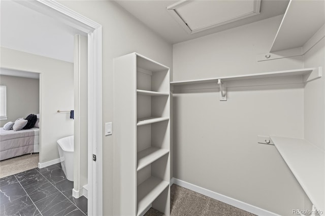 5965 Corinth Dr, Colorado Springs, CO 80923 - spacious closet featuring dark marble finish flooring and attic access