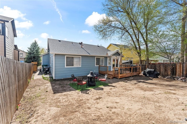 5965 Corinth Dr, Colorado Springs, CO 80923 - back of house with an outdoor fire pit, a deck, a fenced backyard, and roof with shingles