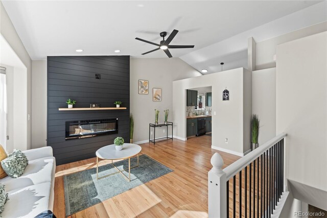 5965 Corinth Dr, Colorado Springs, CO 80923 - living room featuring a fireplace, vaulted ceiling, wood finished floors, recessed lighting, and ceiling fan
