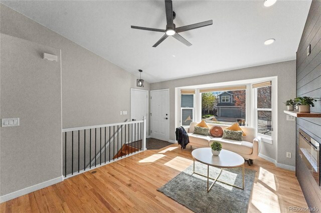 5965 Corinth Dr, Colorado Springs, CO 80923 - living room featuring wood finished floors, vaulted ceiling, a glass covered fireplace, a ceiling fan, and recessed lighting