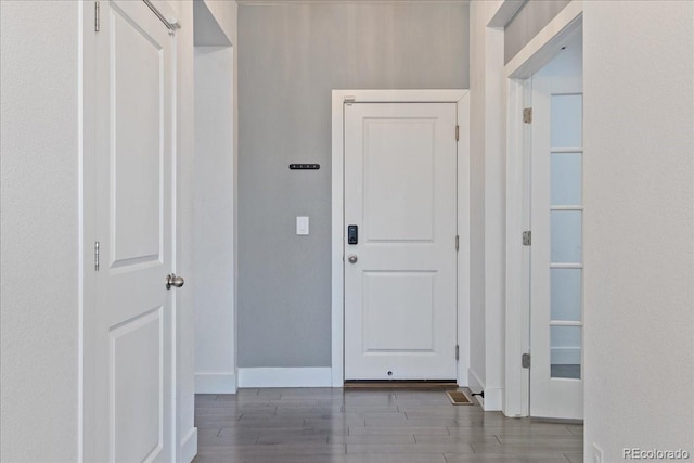 hall with baseboards and wood finished floors