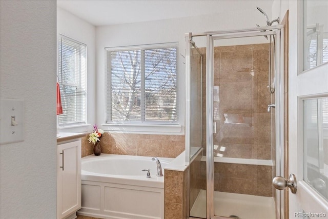 bathroom featuring a bath, a stall shower, and vanity