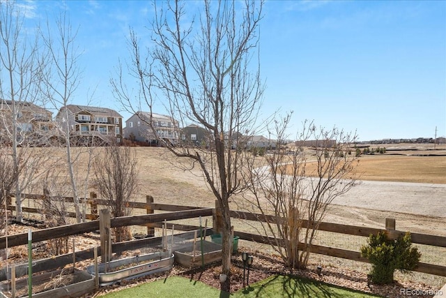 view of yard with a rural view, a vegetable garden, and fence