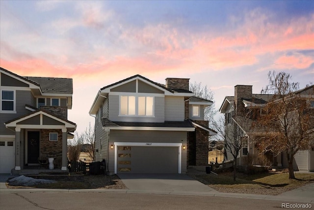 view of front of house with a chimney, an attached garage, and concrete driveway