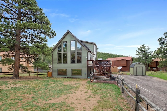 back of house with a storage shed, stairway, an outdoor structure, a wooden deck, and fence