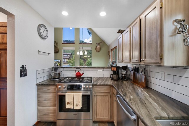 kitchen featuring stainless steel appliances, tasteful backsplash, dark countertops, lofted ceiling, and recessed lighting