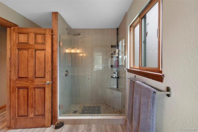 full bathroom with a stall shower and wood finished floors