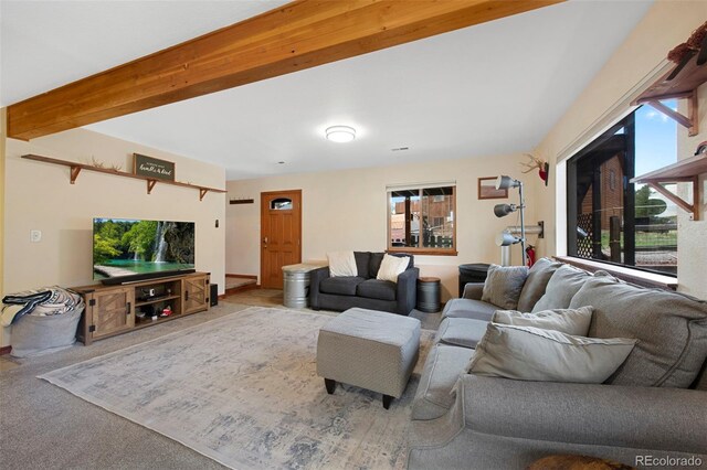 carpeted living area featuring beamed ceiling
