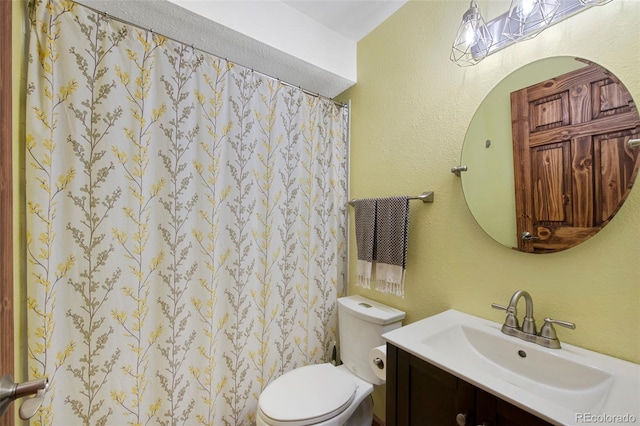 bathroom with toilet, vanity, and a shower with curtain