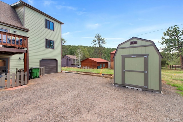 view of shed featuring dirt driveway and a garage