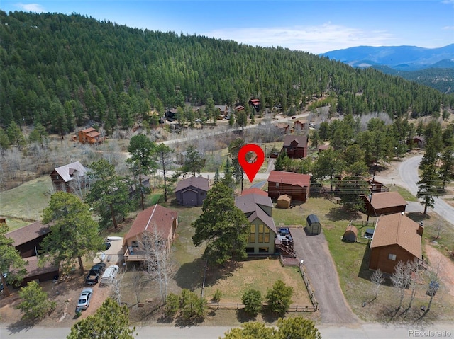aerial overview of property's location with a heavily wooded area and a mountainous background