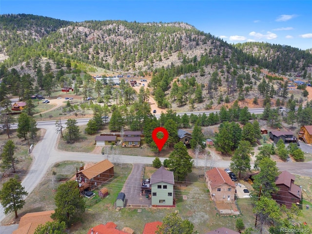 view of property location with a mountain backdrop and a heavily wooded area