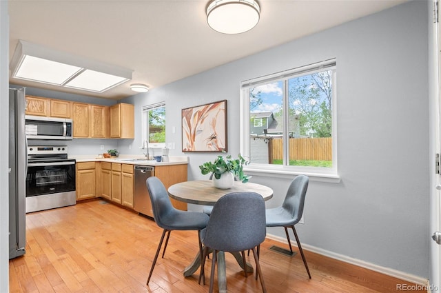 13245 Shoshone St, Denver, CO 80234 - kitchen with stainless steel appliances, a sink, light wood-style floors, light countertops, and baseboards