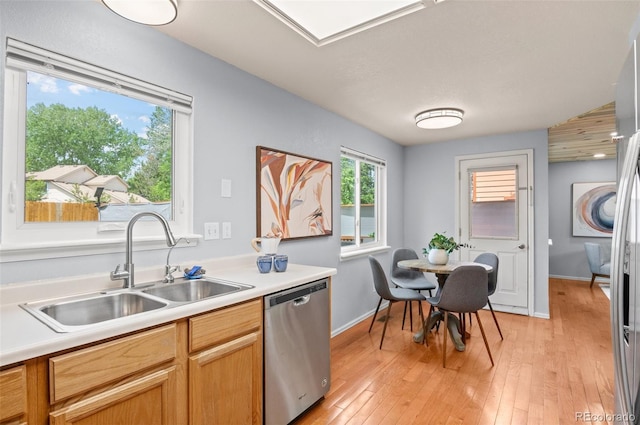 13245 Shoshone St, Denver, CO 80234 - kitchen with stainless steel dishwasher, a sink, light countertops, light wood finished floors, and baseboards