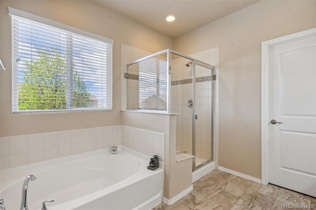 8913 Sunstone Dr, Colorado Springs, CO 80924 - bathroom featuring a bath, plenty of natural light, a shower stall, and baseboards