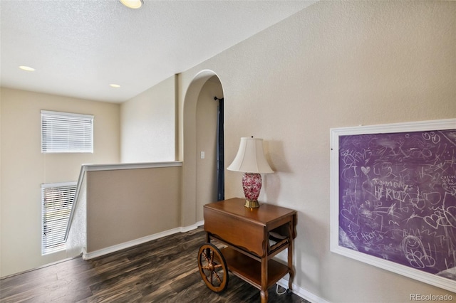 8913 Sunstone Dr, Colorado Springs, CO 80924 - corridor with arched walkways, dark wood finished floors, and baseboards