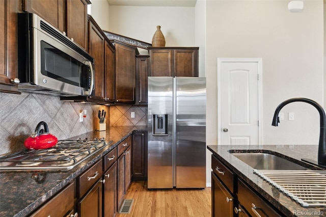 8913 Sunstone Dr, Colorado Springs, CO 80924 - kitchen with stainless steel appliances, a sink, tasteful backsplash, and dark stone counters