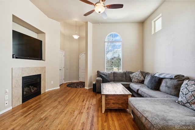 8913 Sunstone Dr, Colorado Springs, CO 80924 - living area featuring a ceiling fan, light wood-style flooring, baseboards, and a tile fireplace